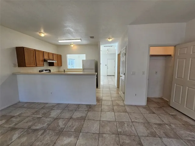 a view of an empty room with a chandelier fan