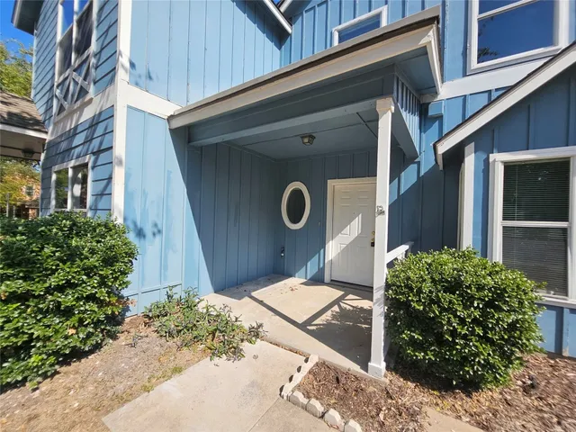 a front view of a house with a yard and potted plants