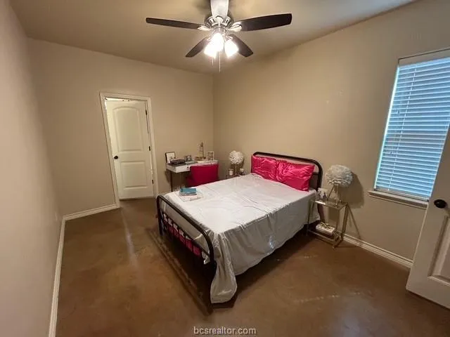 a spacious bedroom with a bed and a chandelier
