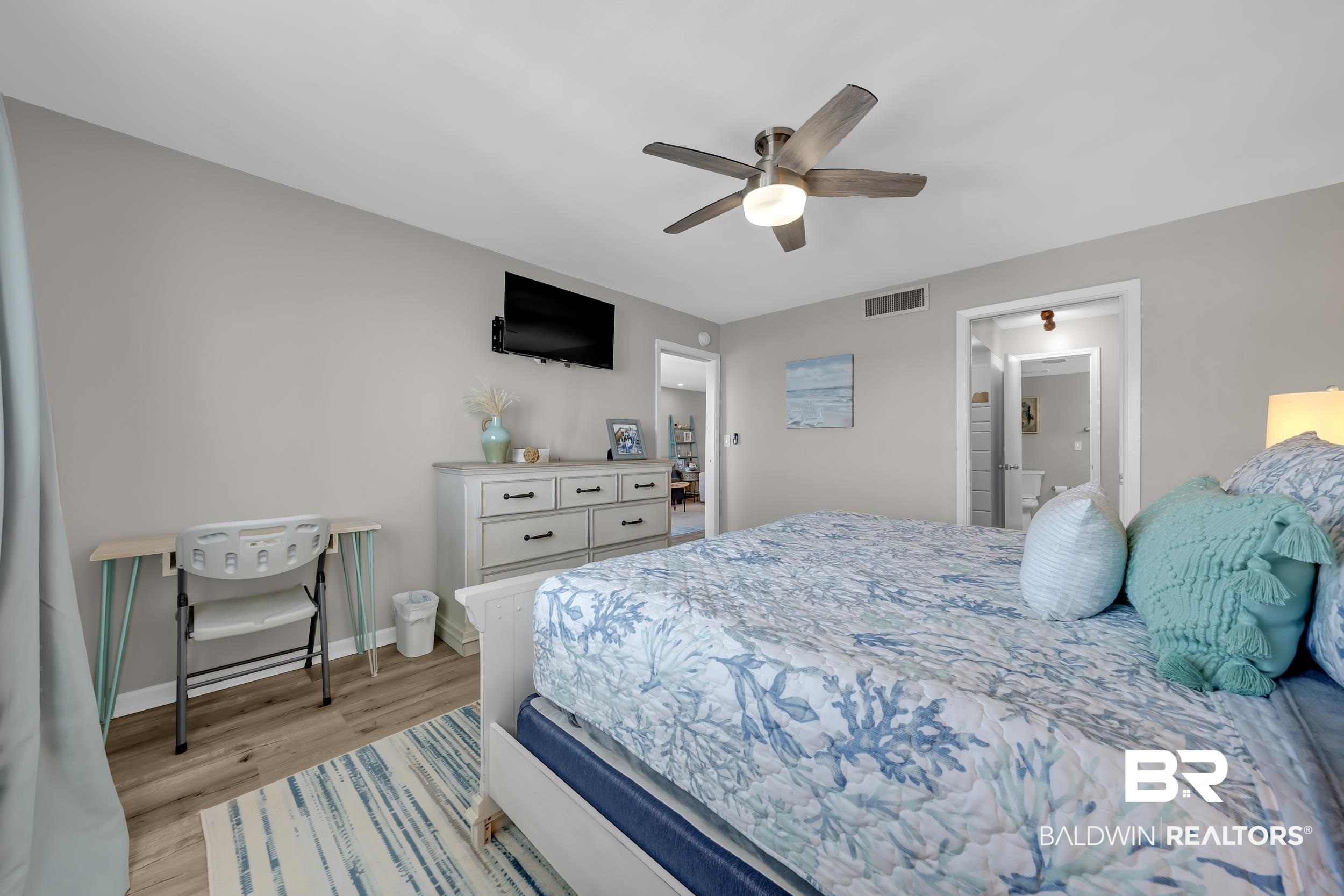 14100 River Road, Unit 211 Pensacola, FL 32507 - Photo 25 of 56 Bedroom featuring wood-finish flooring, light grey wall paint, and a ceiling fan with integrated lighting