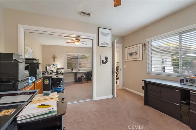 a view of a livingroom with workspace and a window