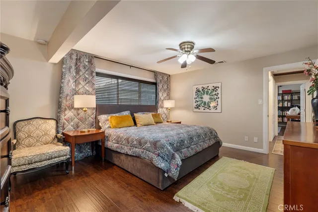 a bedroom with a bed wooden floor and window