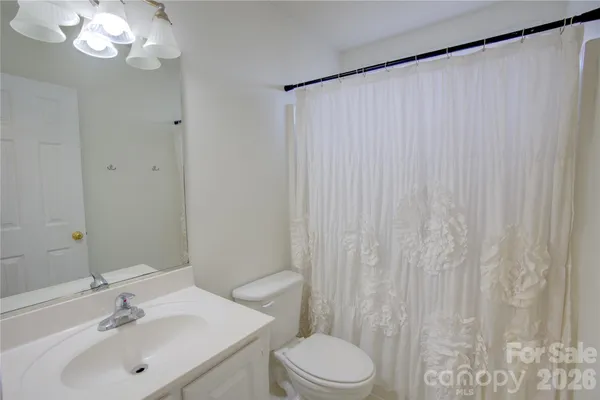 a bathroom with a sink a toilet and shower curtain