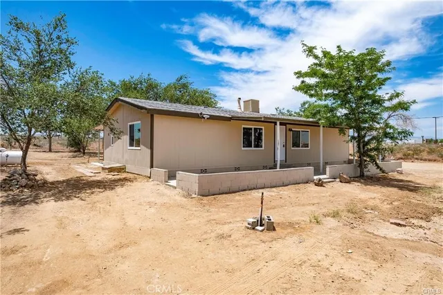 a backyard of a house with table and chairs