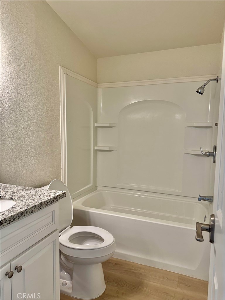 12782 Atsina Road Phelan, CA 92371 - Photo 11 of 18 a bathroom with a granite countertop toilet and a bathtub