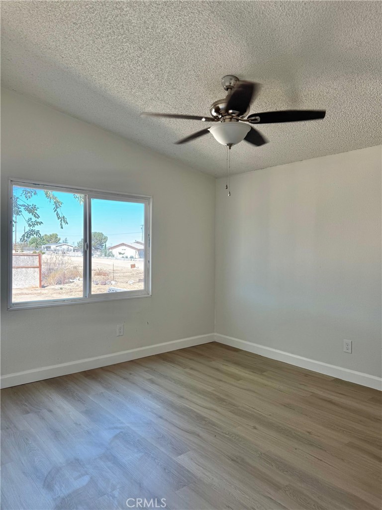 12782 Atsina Road Phelan, CA 92371 - Photo 13 of 18 wooden floor in an empty room with a window