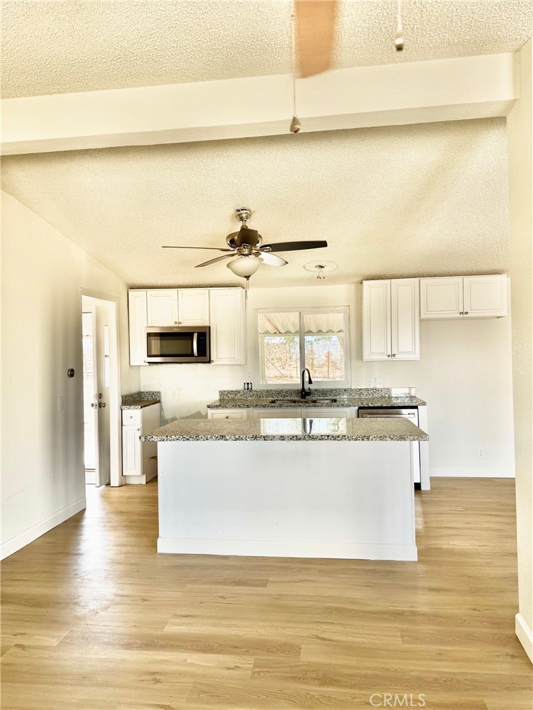 12782 Atsina Road Phelan, CA 92371 - Photo 6 of 18 a view of kitchen with stainless steel appliances wooden floor