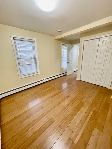a view of empty room with wooden floor