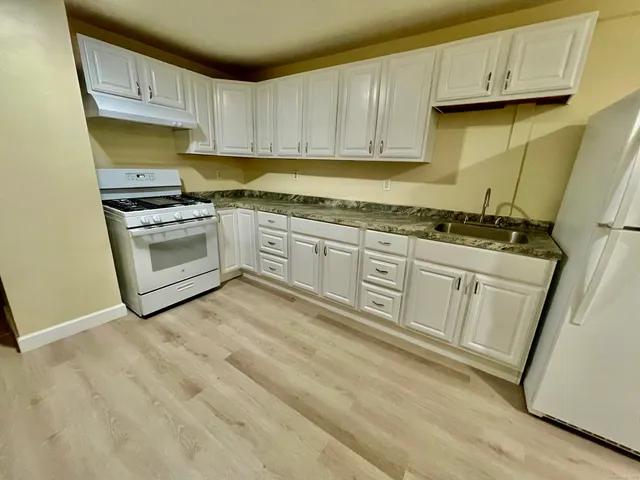a kitchen with stainless steel appliances granite countertop a stove a sink and a microwave