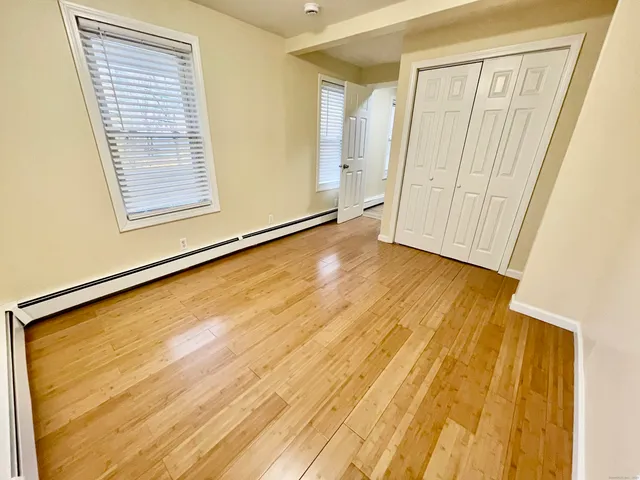 a view of a room with wooden floor and a window