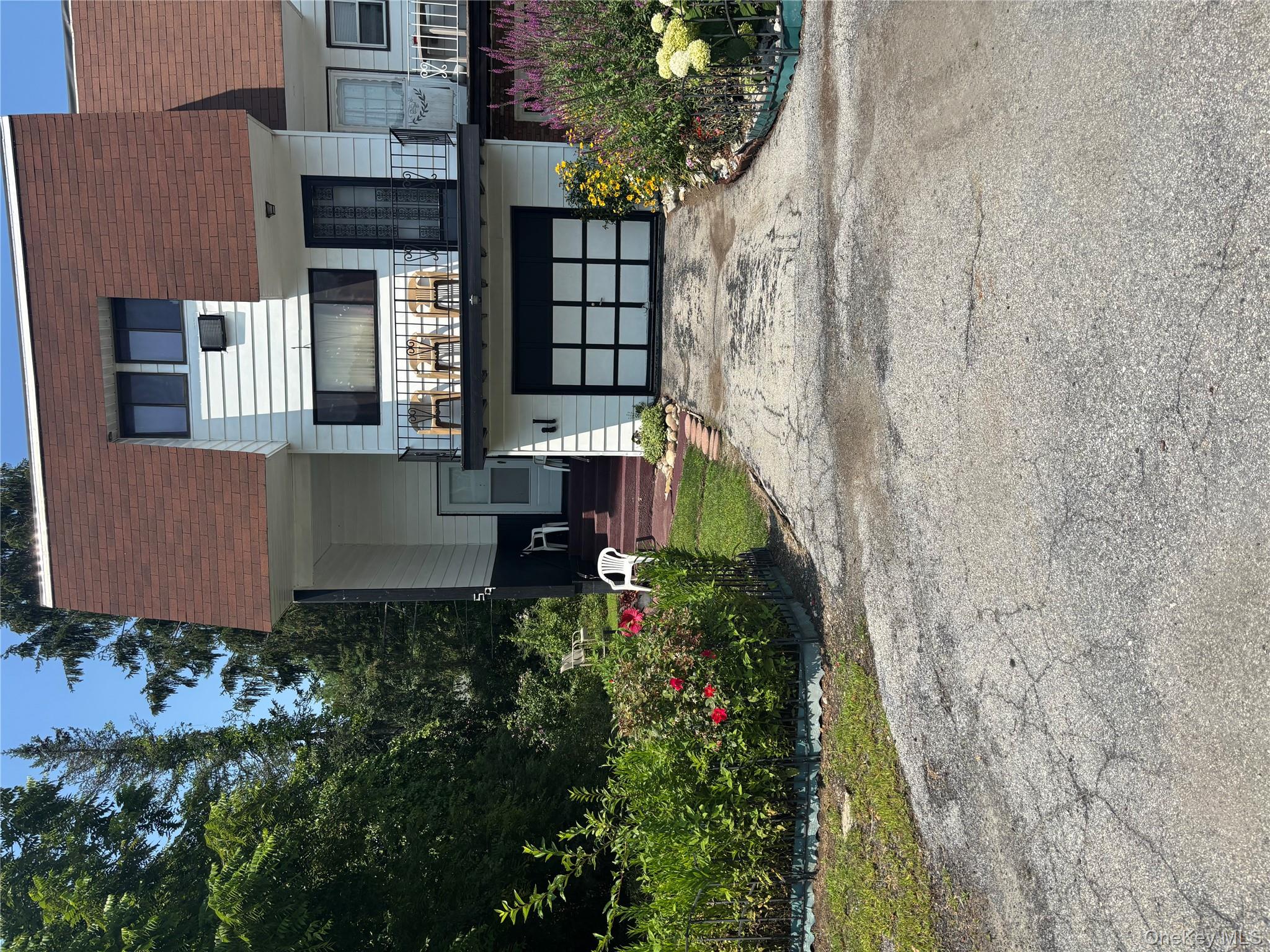 View of front of house featuring a shingled roof, mansard roof, asphalt driveway, and an attached garage