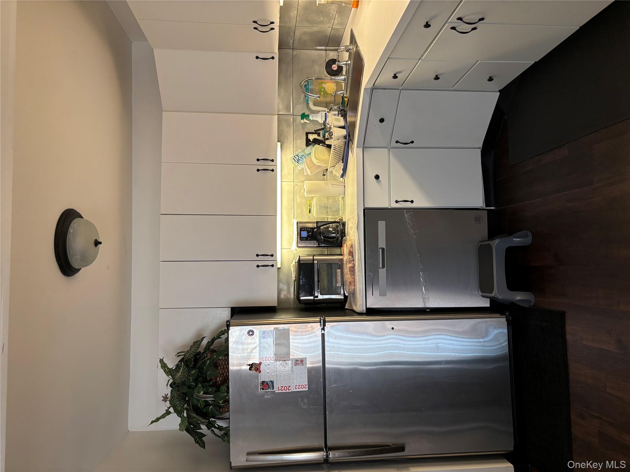 59 Windmill Road Hyde Park, NY 12601 - Photo 3 of 13 Kitchen with light countertops, fridge, and white cabinetry