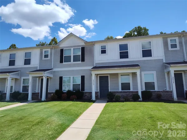 a view of a yard in front of a brick house with a large windows