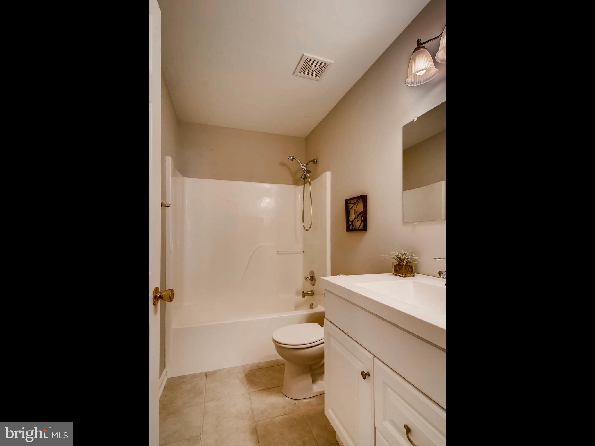 1606 Frederick Road Baltimore, MD 21228 - Photo 19 of 28 a bathroom with a granite countertop toilet a sink and a shower