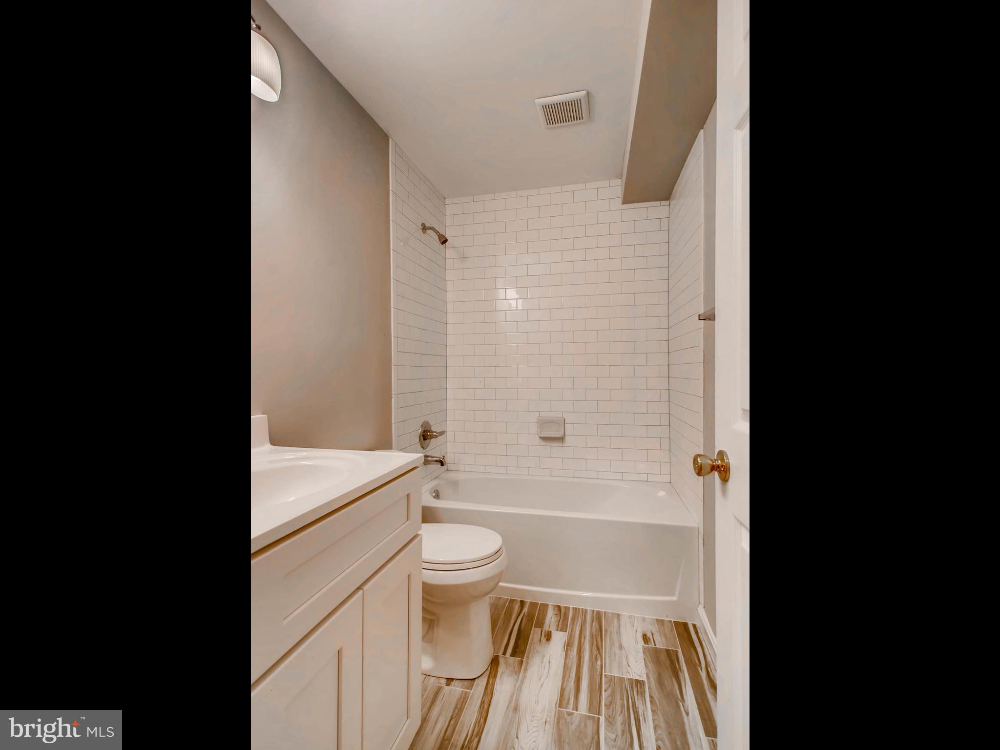 1606 Frederick Road Baltimore, MD 21228 - Photo 25 of 28 a bathroom with a sink a toilet and a shower