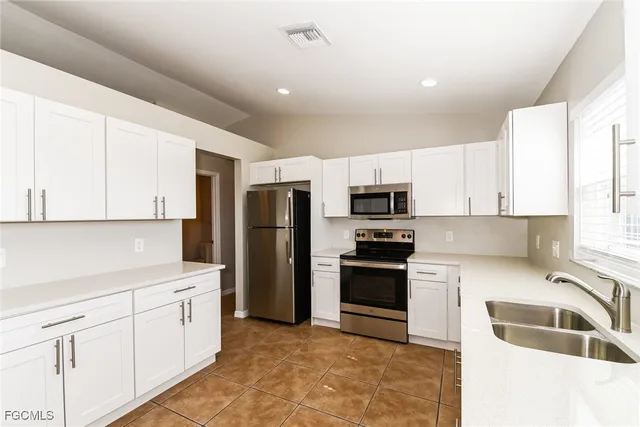 a kitchen with stainless steel appliances granite countertop a refrigerator sink and stove