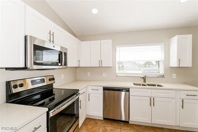 a kitchen with granite countertop white cabinets and appliances