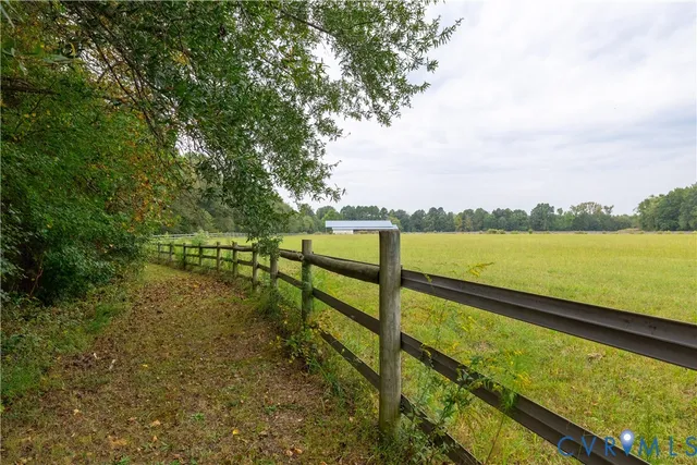 a view of outdoor space with a field and trees in the background