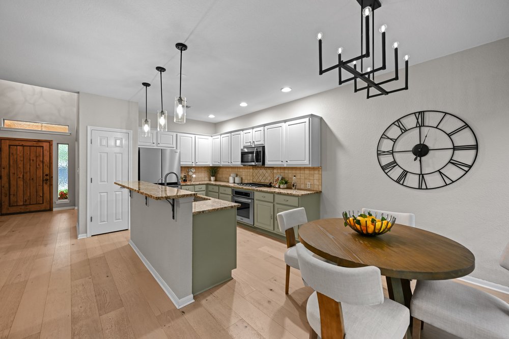 2823 Lantana Ridge Drive Austin, TX 78732 - Photo 13 of 34 a kitchen with stainless steel appliances kitchen island a table and chairs in it