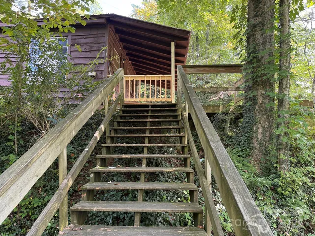 a view of a house with a yard balcony and wooden fence