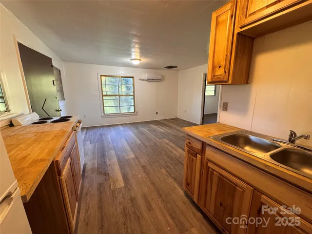 a kitchen that has a sink and wooden floor