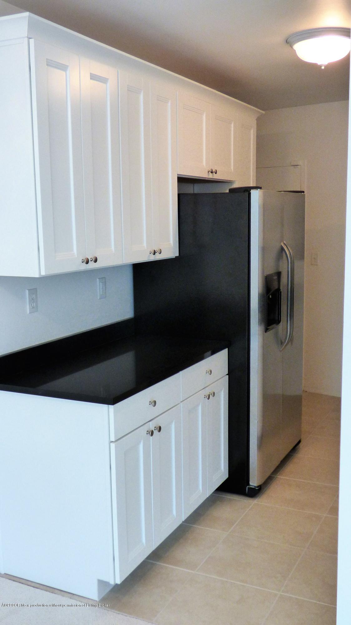 44 Cocoanut Row, Unit 308B Palm Beach, FL 33480 - Photo 7 of 14 a kitchen with white cabinets and refrigerator