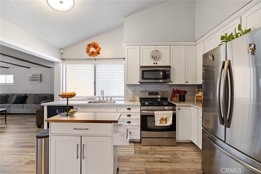 638 Eston Place Lancaster, CA 93535 - Photo 14 of 44 a kitchen with stainless steel appliances a stove microwave and a refrigerator