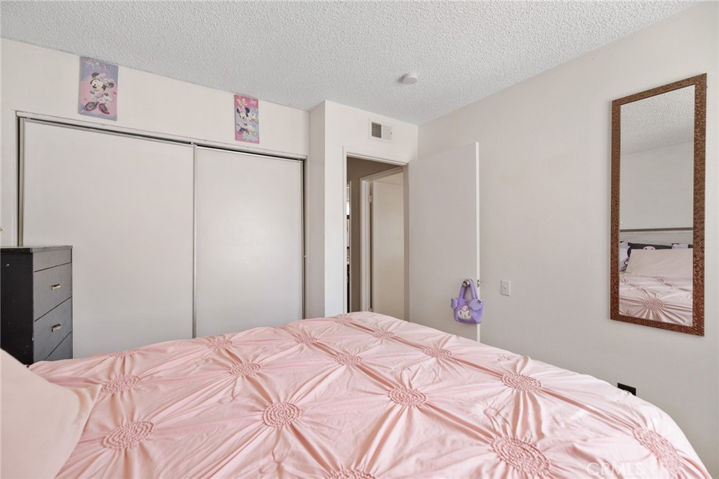 638 Eston Place Lancaster, CA 93535 - Photo 30 of 44 a bedroom with a bed and a refrigerator