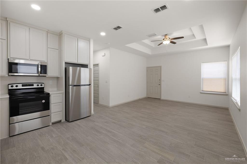 740 North Alamo Road, Unit 2 Alamo, TX 78516 - Photo 11 of 24 a view of a kitchen with a sink a ceiling fan and stainless steel appliances