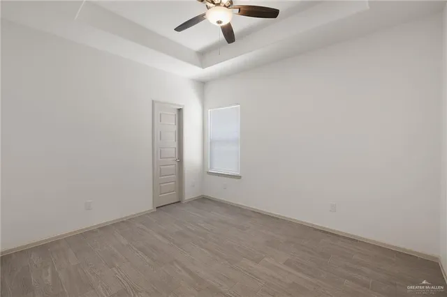 an empty room with a ceiling fan and window