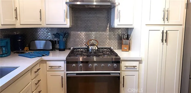 a stove top oven sitting inside of a kitchen