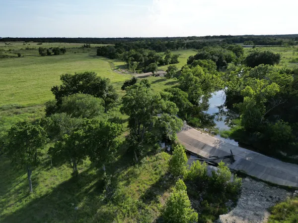 an aerial view of a houses with a yard and lake view