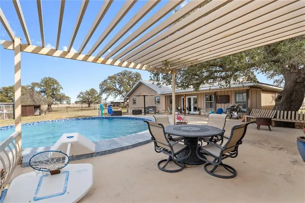 a view of a patio with table and chairs with wooden floor and fence