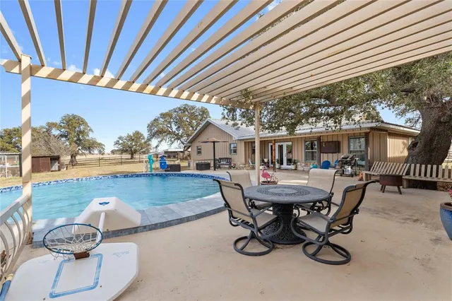 a view of a patio with table and chairs with wooden floor and fence