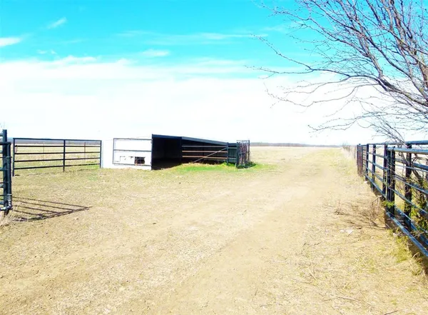 a view of backyard with wooden fence