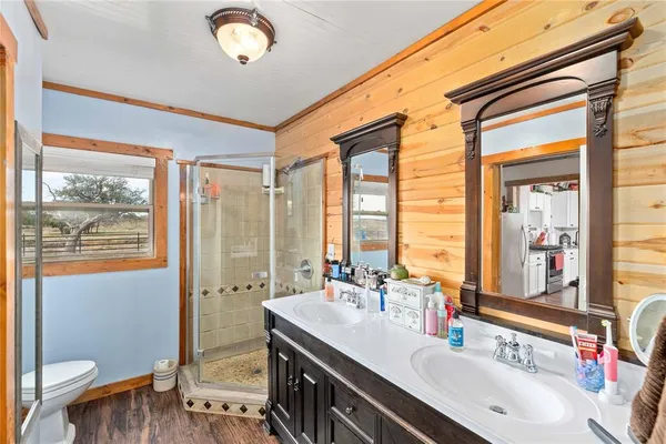 a bathroom with a double vanity sink toilet and a tub