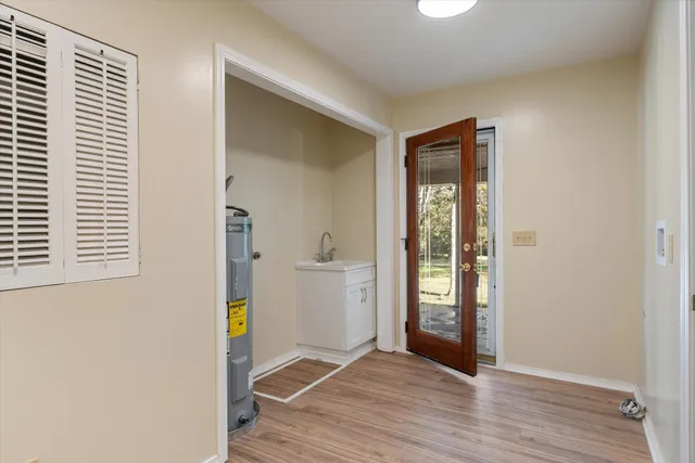 an empty room with wooden floor closet and windows
