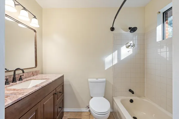 a bathroom with a granite countertop sink a toilet and a mirror