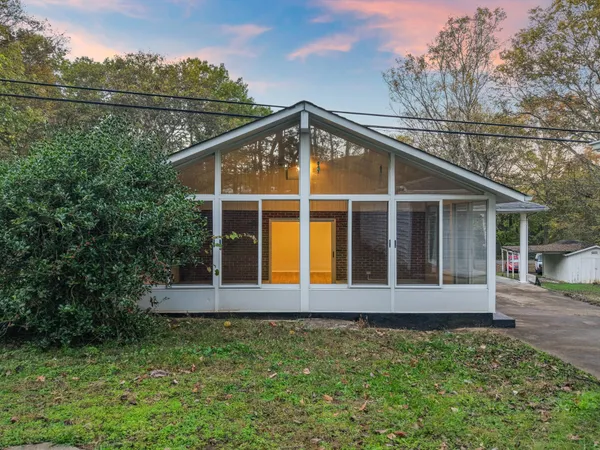 a view of a house with a yard and sitting area