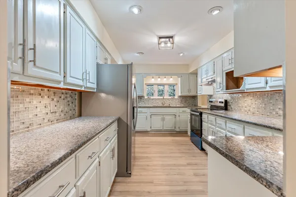 a kitchen with stainless steel appliances granite countertop a stove a sink and a granite counter tops