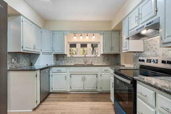 a kitchen with a refrigerator sink and cabinets