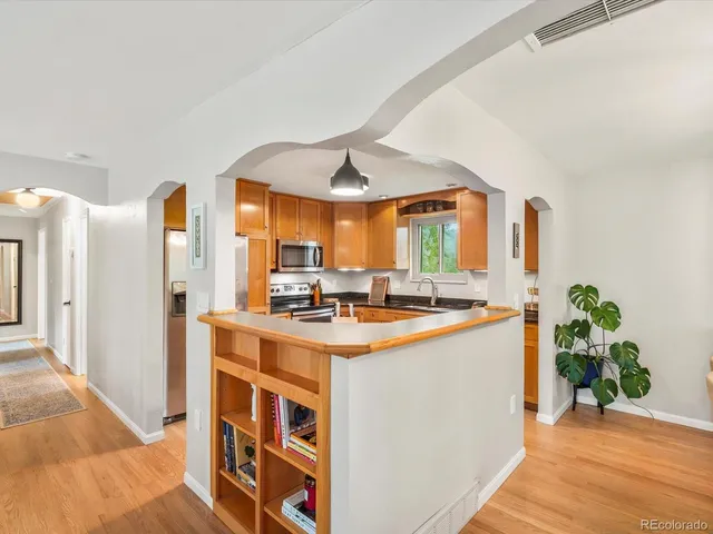 a kitchen with stainless steel appliances granite countertop a stove a refrigerator and a dining table