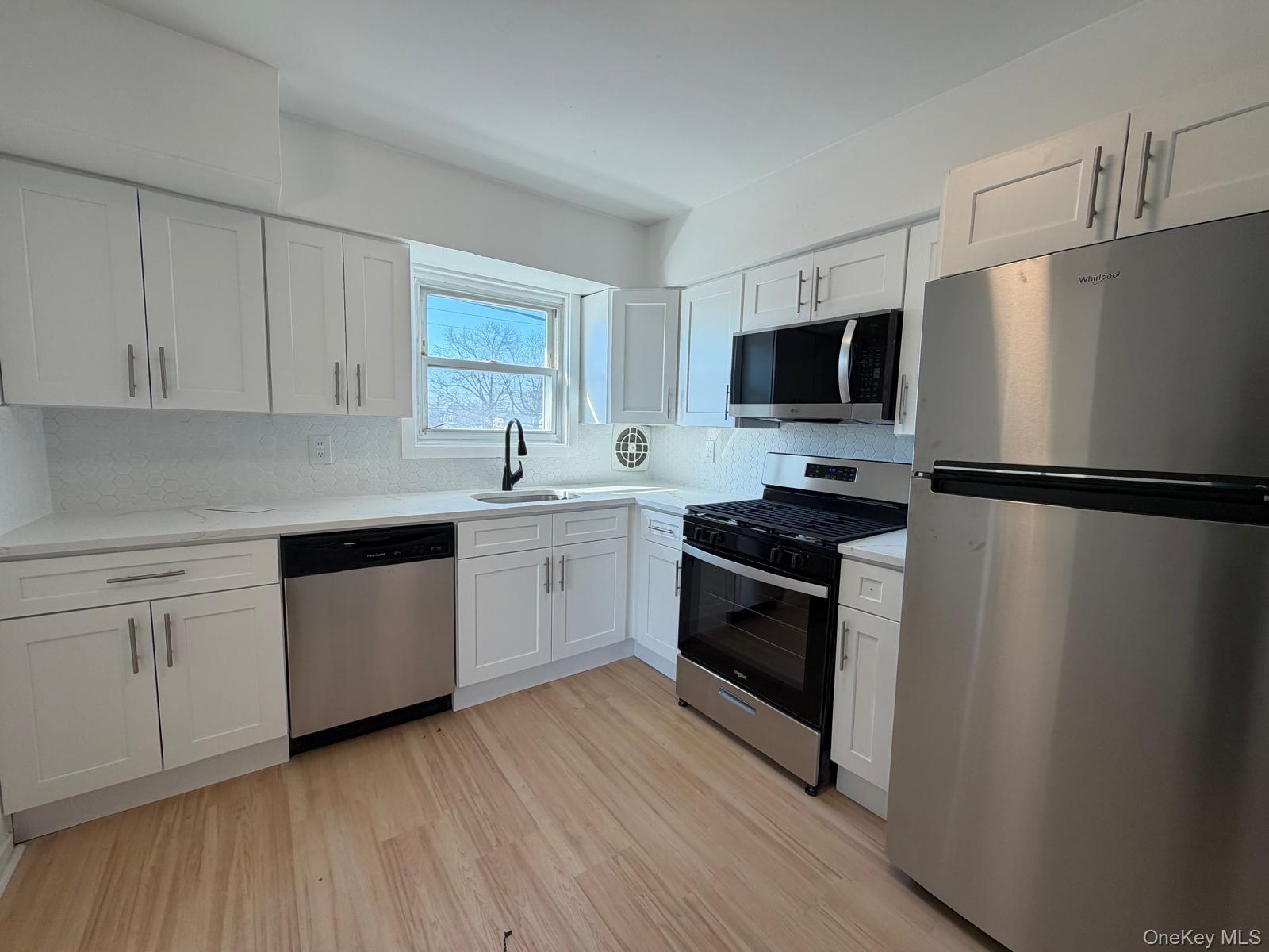 1 Munro Boulevard, Unit 2F Valley Stream, NY 11581 - Photo 1 of 1 a kitchen with a sink stove and refrigerator