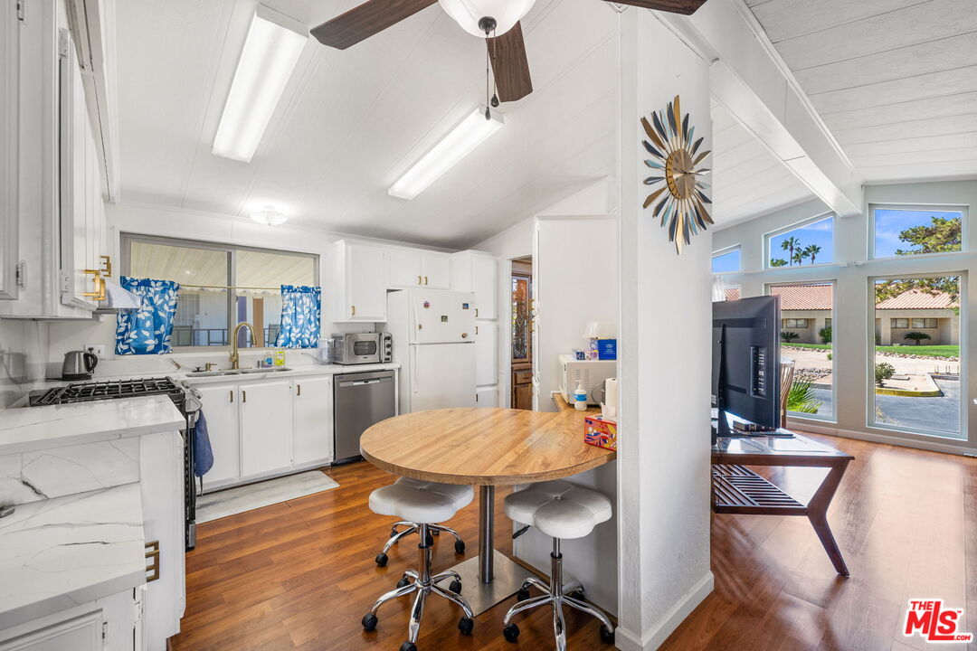 74711 Dillon Road, Unit 503 Desert Hot Springs, CA 92241 - Photo 12 of 52 a kitchen with a table chairs refrigerator and cabinets