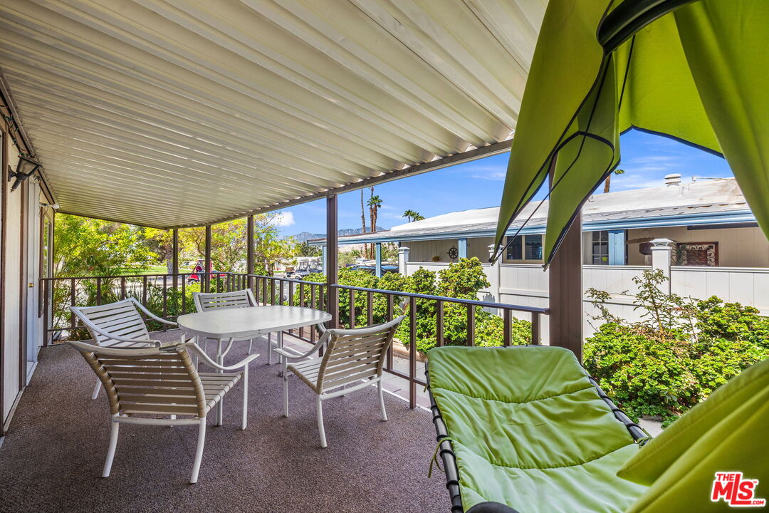 74711 Dillon Road, Unit 503 Desert Hot Springs, CA 92241 - Photo 28 of 52 a view of a patio with a table and chairs under an umbrella