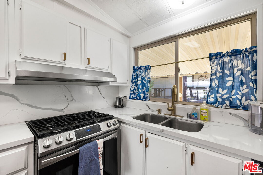 74711 Dillon Road, Unit 503 Desert Hot Springs, CA 92241 - Photo 30 of 52 a kitchen with a sink a stove and cabinets