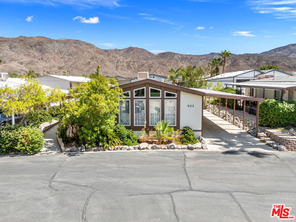 74711 Dillon Road, Unit 503 Desert Hot Springs, CA 92241 - Photo 3 of 52 a front view of a house with a yard and mountain view