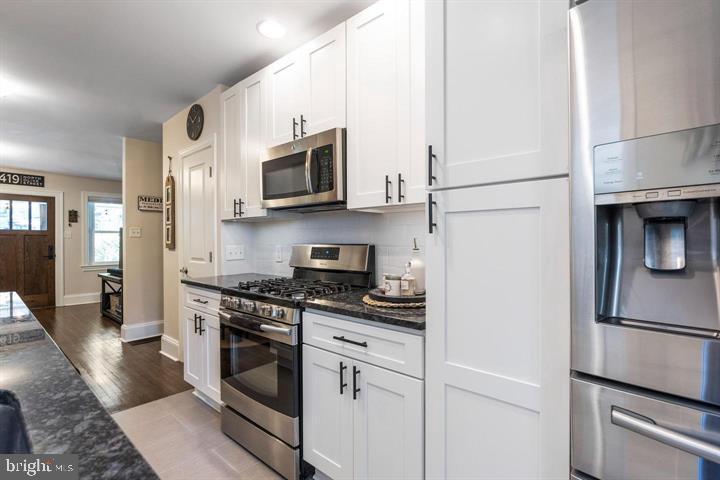 419 North Olive Street Media, PA 19063 - Photo 13 of 31 a kitchen with stainless steel appliances granite countertop white cabinets a stove a microwave and a refrigerator