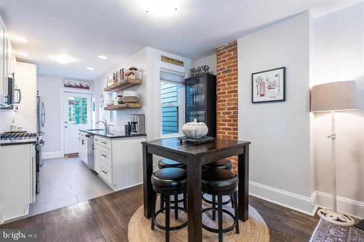 419 North Olive Street Media, PA 19063 - Photo 9 of 31 a kitchen with stainless steel appliances kitchen island granite countertop a table chairs cabinets and wooden floor