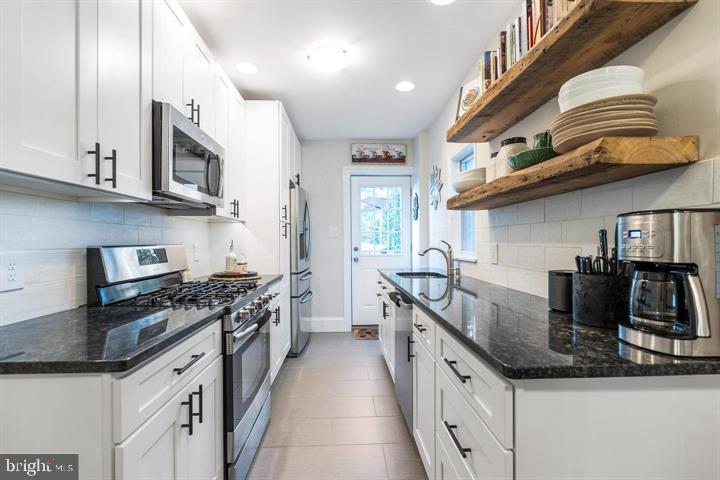 419 North Olive Street Media, PA 19063 - Photo 10 of 31 a kitchen with stainless steel appliances granite countertop a sink a stove and a refrigerator